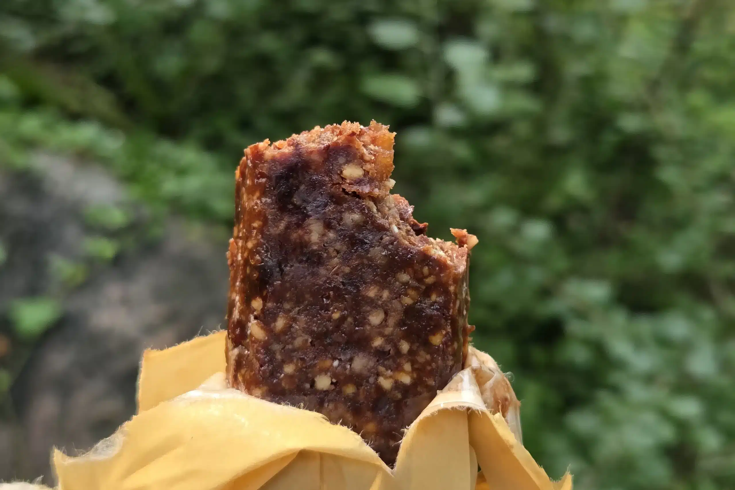 Aufgeschnittene Wanderbar Kakao in geöffneter Verpackung vor einem Waldhintergrund
